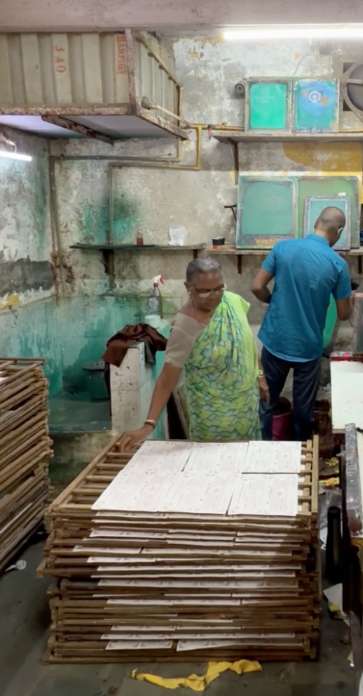Laxmi places wedding invitations on the drying rack