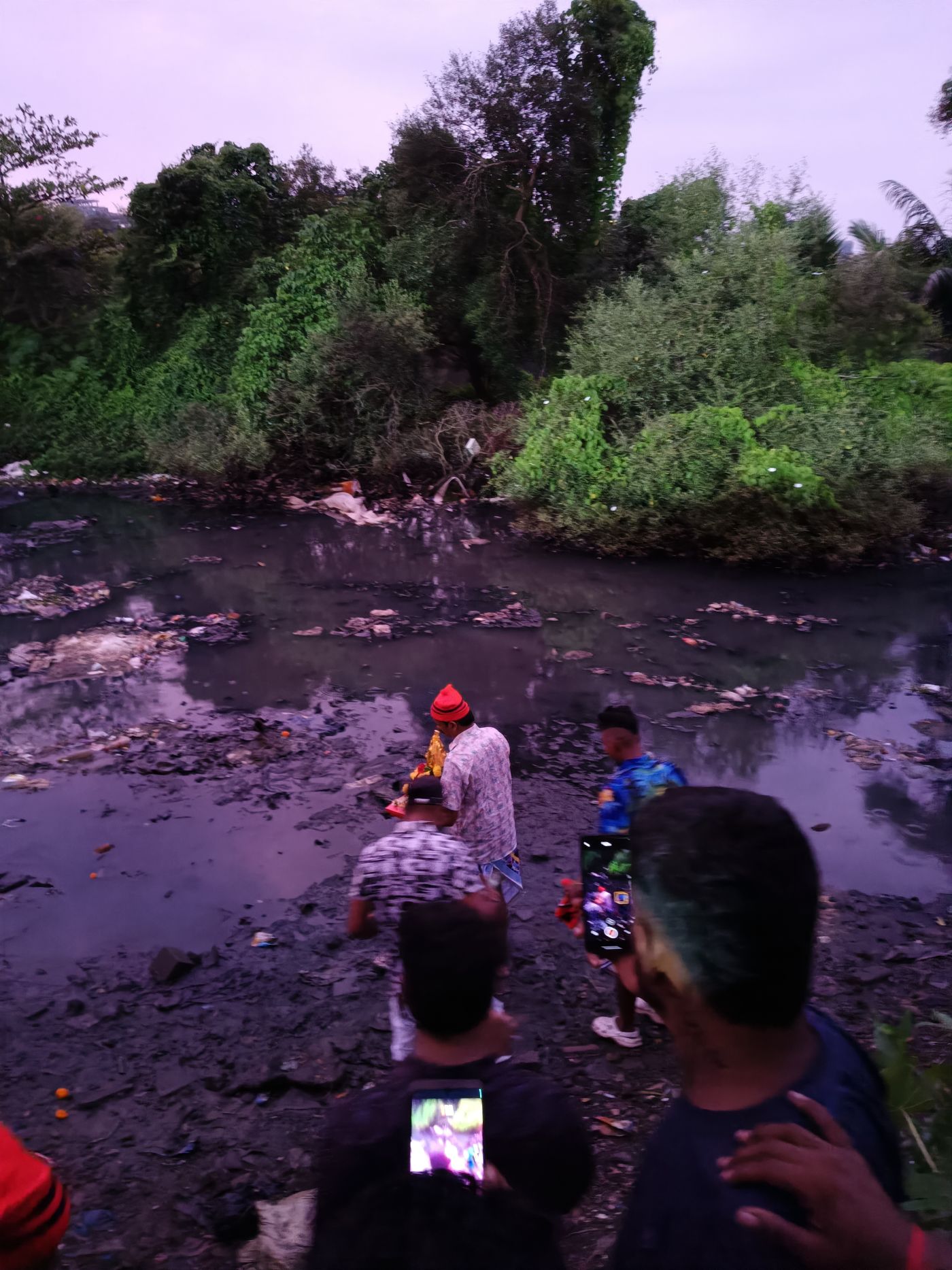 Immersing the Naral (Coconut) offering in the Mithi river