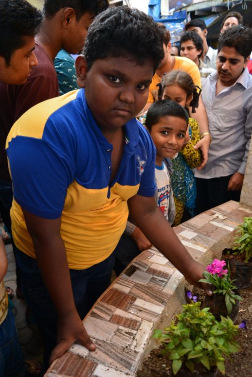 Kids planting flowers as a symbolic gesturing expressing their desire for the improvement of the space where they meet and play. Far left, Gulzar Khan, Waqar’s son.