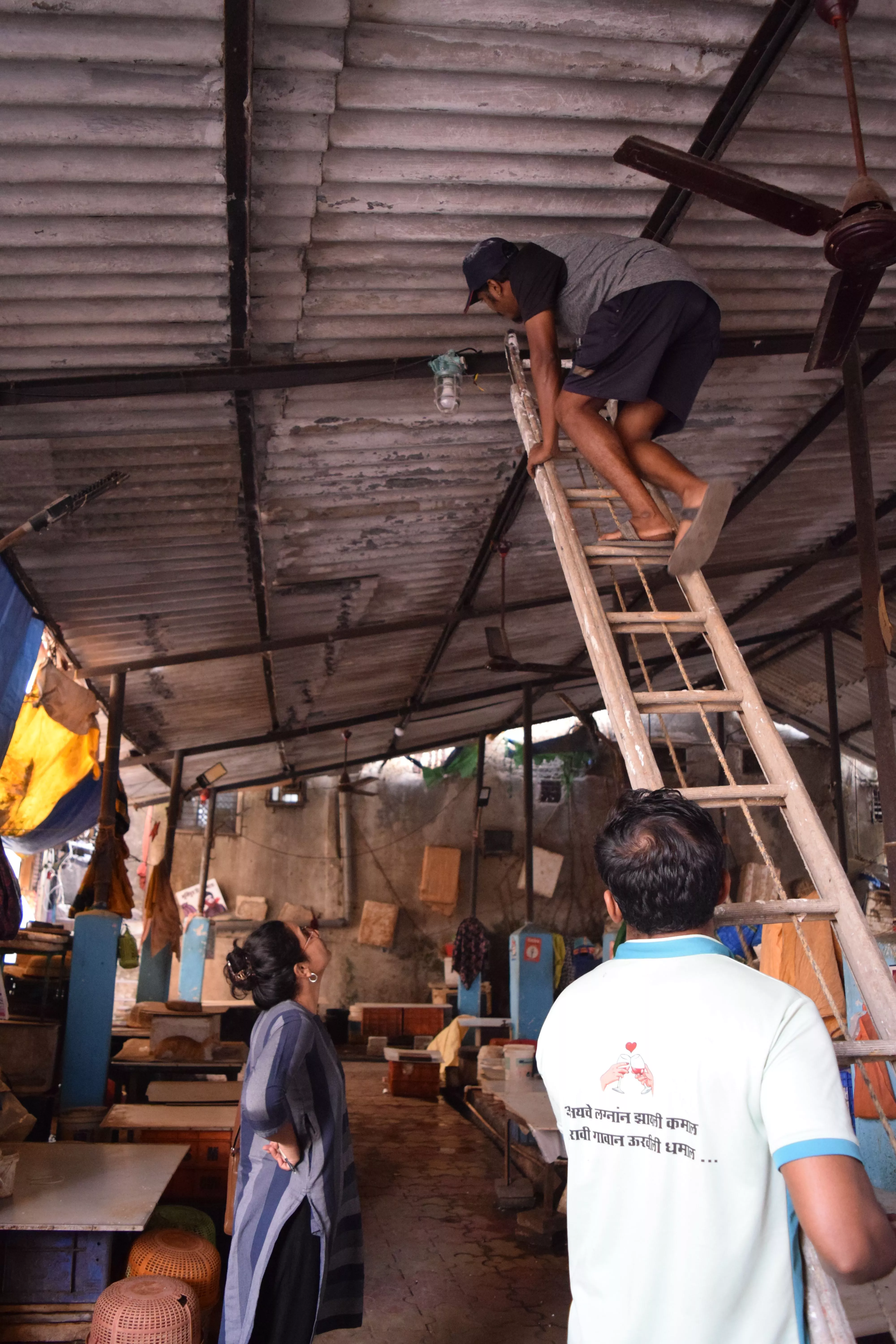 Local electricians, Vicky and Ankush, instal lights at the local fish market