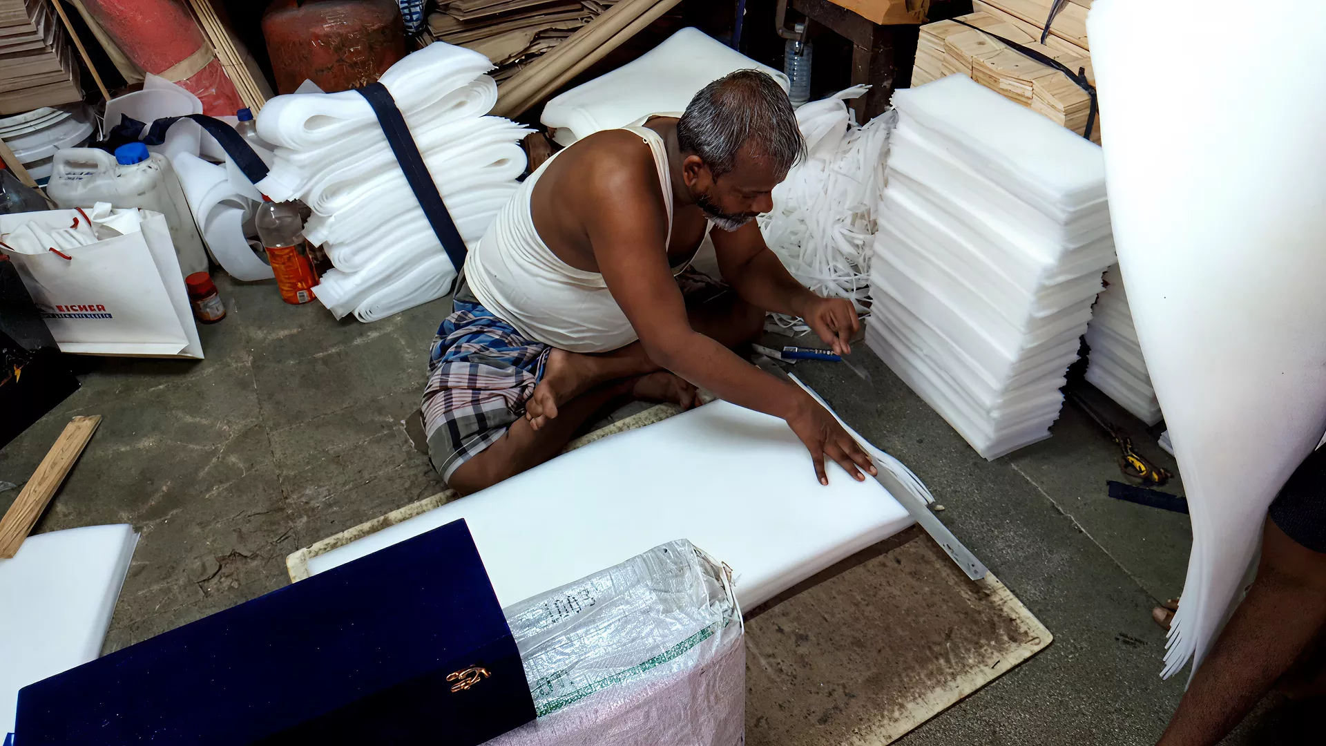 One of the workers precisely cutting foam sheets